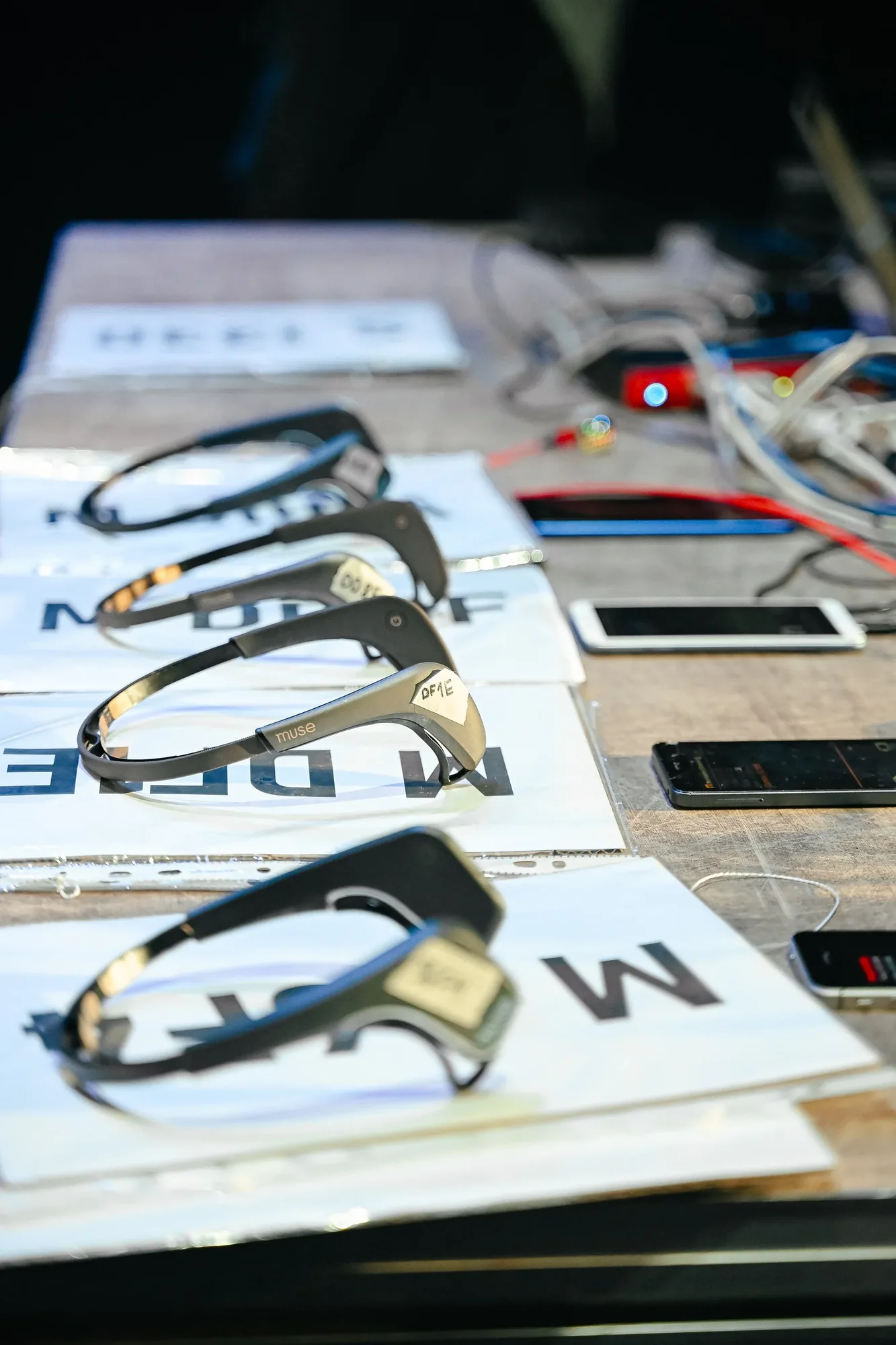 Neuroheadsets and phones laid out on a table.
