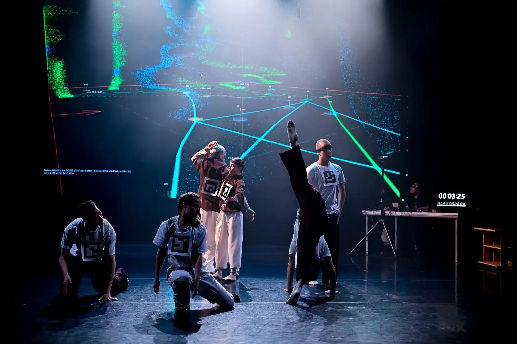 Performers moving in front of a projected digital grid.